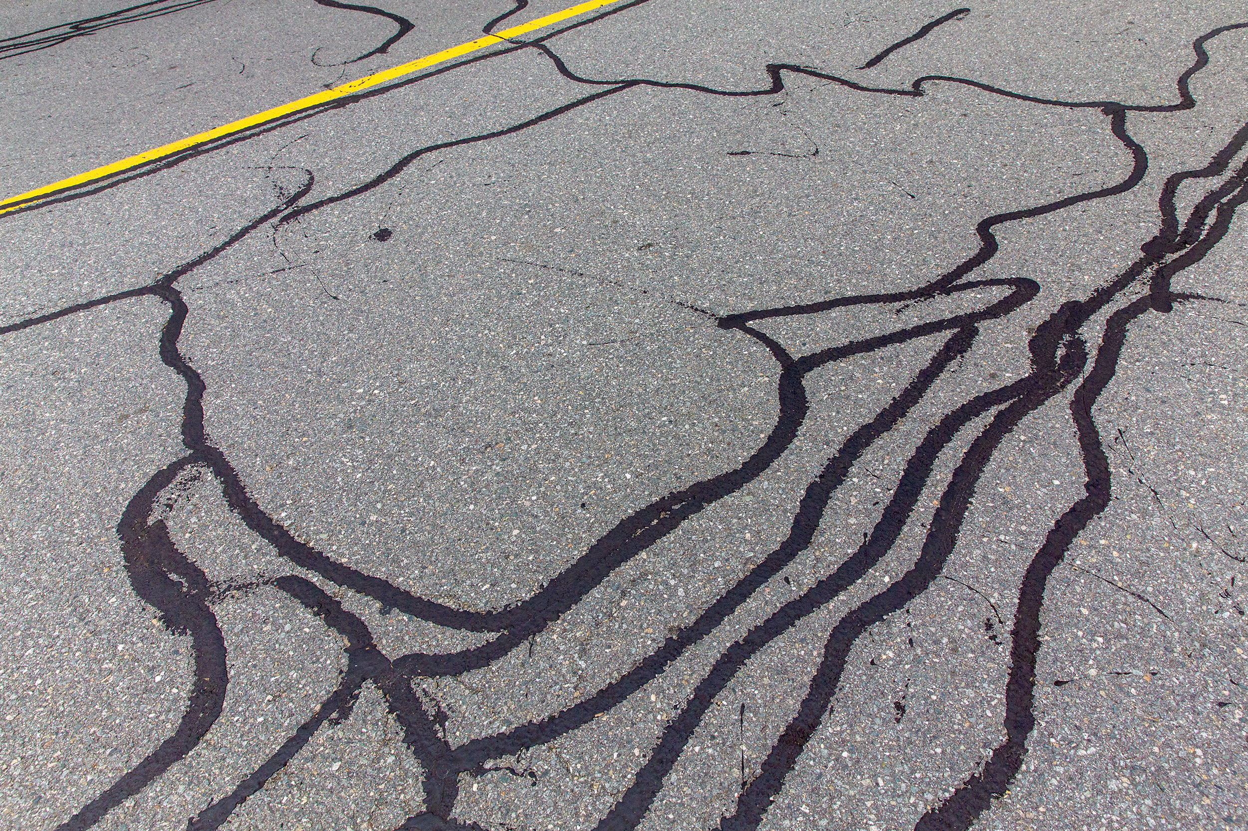 Asphalt,Road,With,Filled,Cracks.,Background,Of,The,Fixed,Road